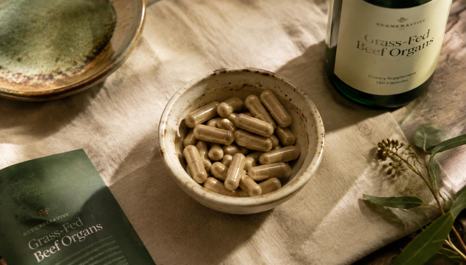 Grass-fed beef organ supplement capsules in a ceramic bowl